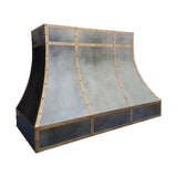 curved antique zinc custom range hood with antique brass grid trim and decorative rivets left side view