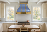 polished stainless steel range hood with mirror polished brass straps and aprons in farmhouse kitchen